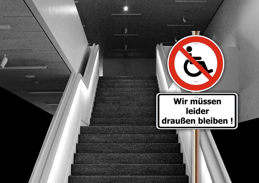 En Rollstuhl steht am Fuß einer Rolltreppe. auf einem Verbotsschid daneben steht in einem roten Kreis Wir müpssen leider draußen bleiben.